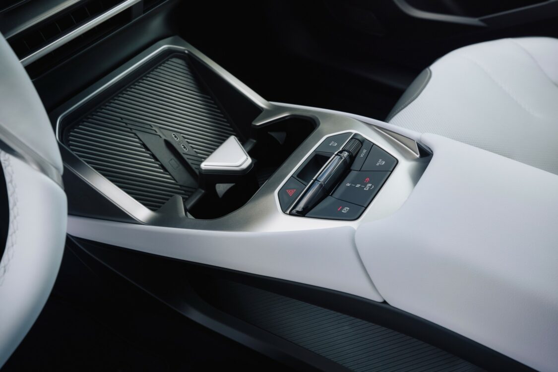 BMW iX3 – design minimaliste de la console centrale Vue latérale de la console centrale de la BMW iX3, avec commandes de transmission et rangement supérieur texturé.