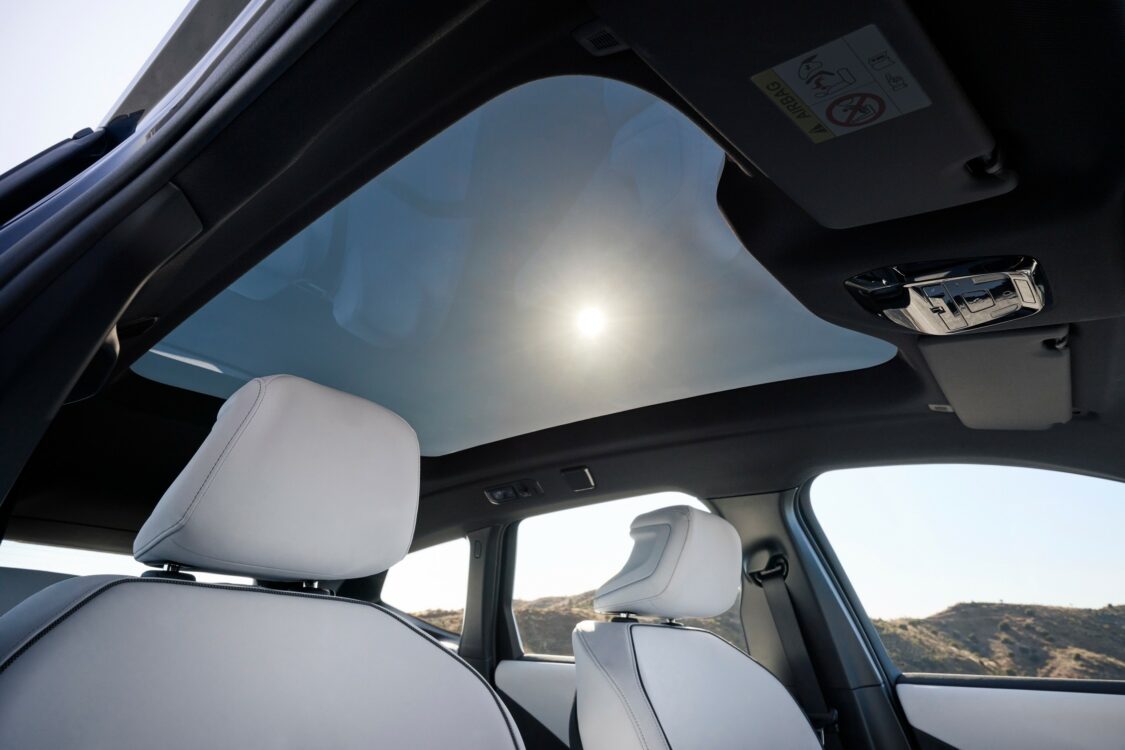 BMW iX3 – toit panoramique vitré Vue intérieure de la BMW iX3 avec toit panoramique vitré laissant entrer la lumière naturelle.