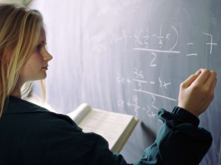 Une lycéenne au tableau entrain de résoudre une équation