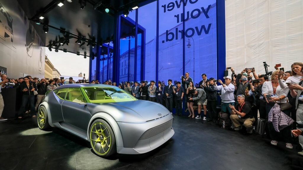 Hyundai Concept Three exposé à l’IAA Mobility 2025, entouré de journalistes et photographes.