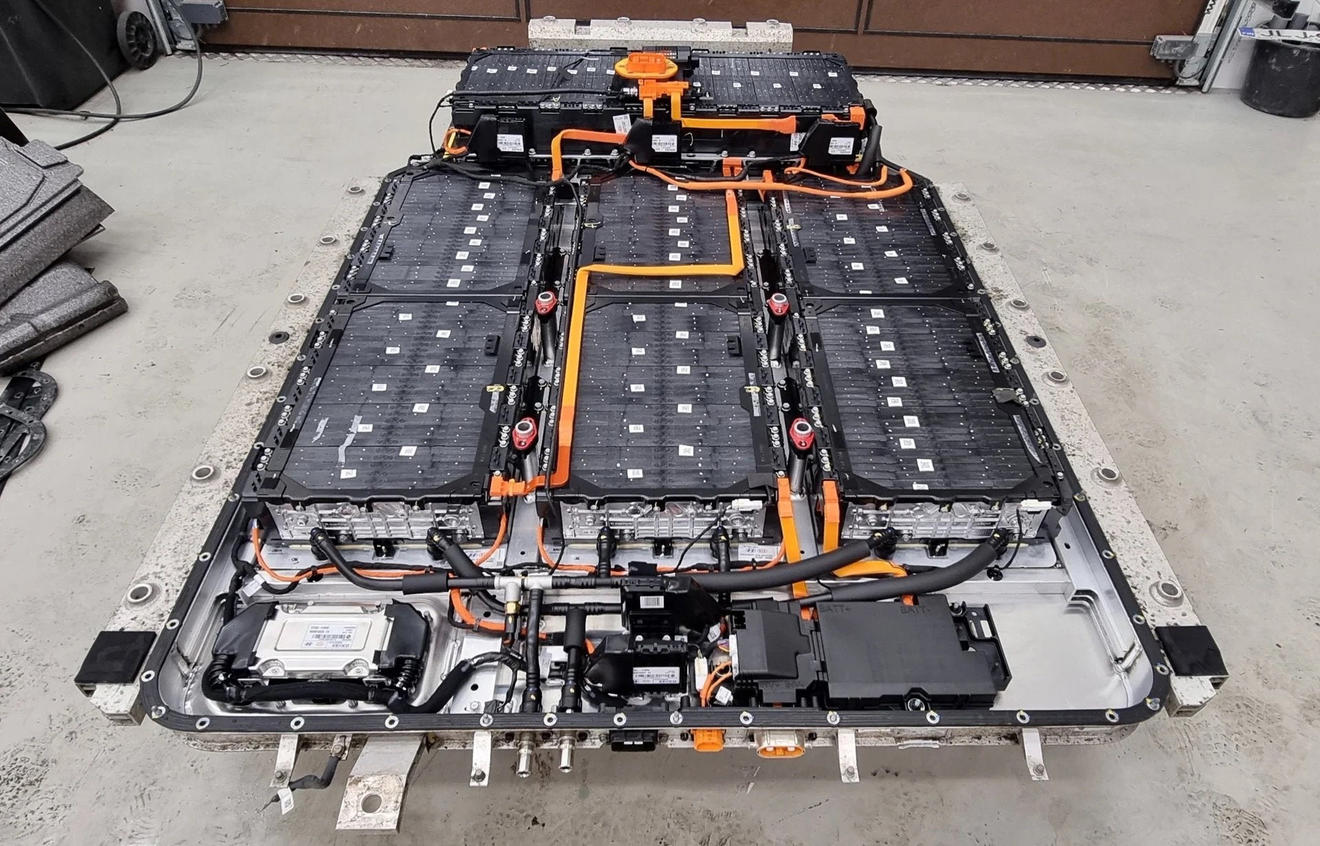 Pack batterie haute tension d’un véhicule Kia électrique, avec modules et connectiques visibles.