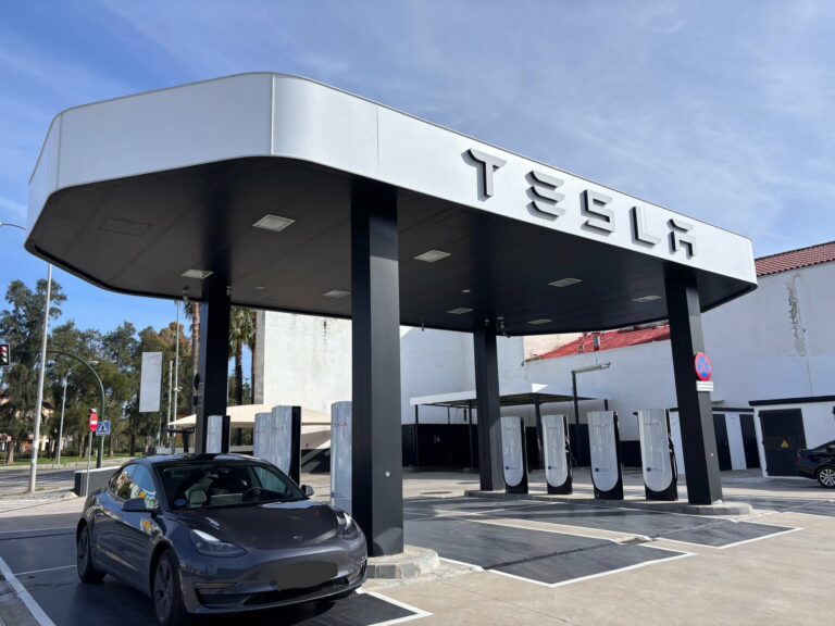 Station Tesla Supercharger sous auvent avec Model 3 en charge